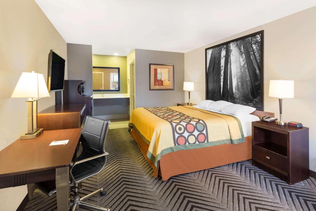 a hotel room with a bed and a desk at Super 8 by Wyndham Fortuna in Fortuna