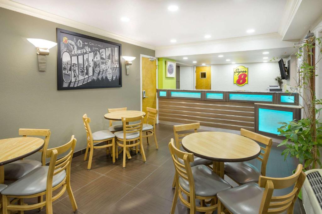 a dining room with tables and chairs in a restaurant at Super 8 by Wyndham Fortuna in Fortuna