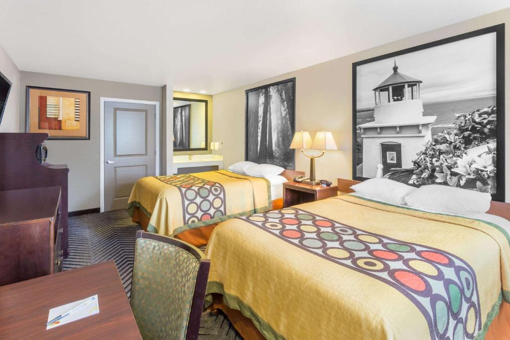 a hotel room with two beds and a table at Super 8 by Wyndham Fortuna in Fortuna
