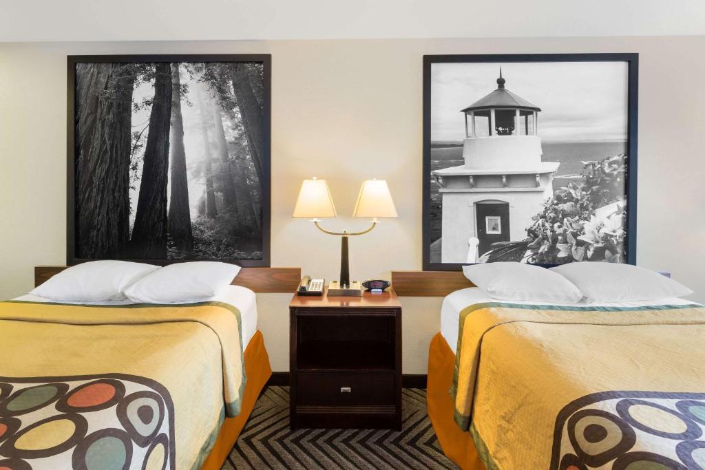 a hotel room with two beds and a lighthouse on the wall at Super 8 by Wyndham Fortuna in Fortuna