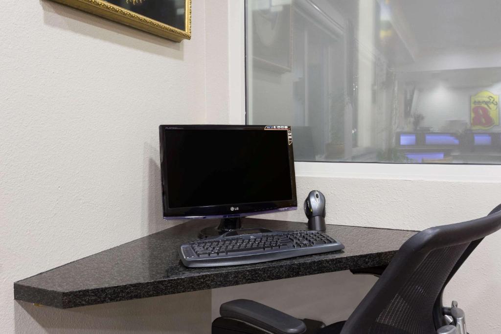 a computer monitor and keyboard sitting on a desk at Super 8 by Wyndham Fortuna in Fortuna