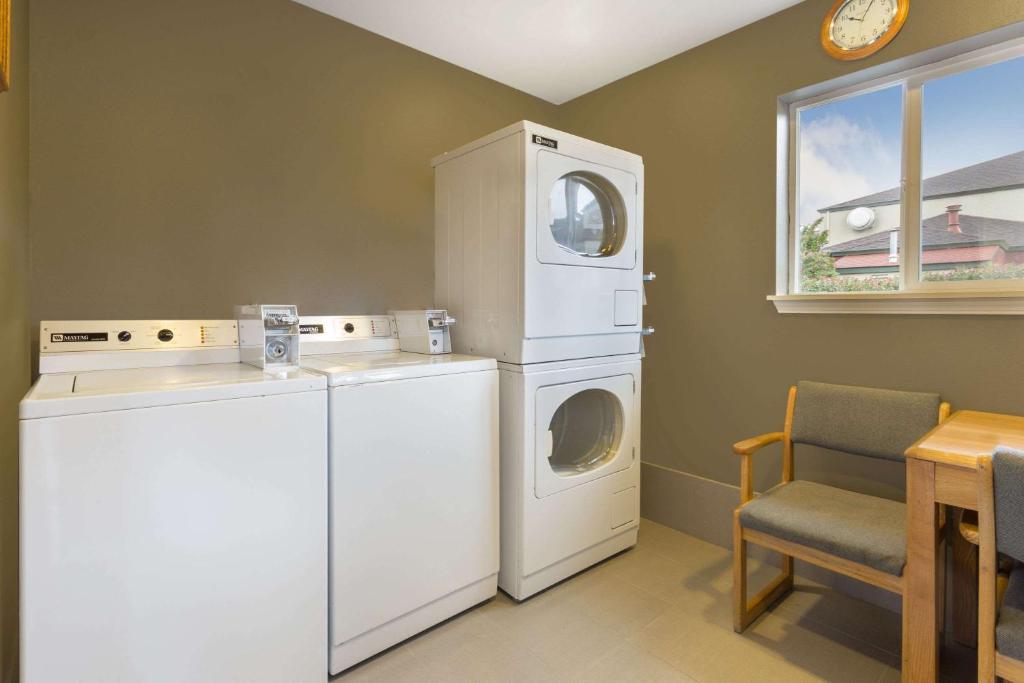 a laundry room with a washing machine and a washer at Super 8 by Wyndham Fortuna in Fortuna