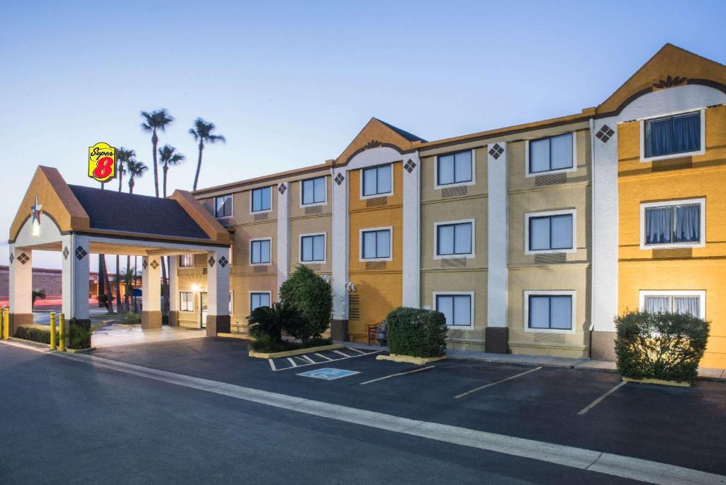 a hotel with a parking lot in front of it at Super 8 by Wyndham Harlingen TX in Harlingen