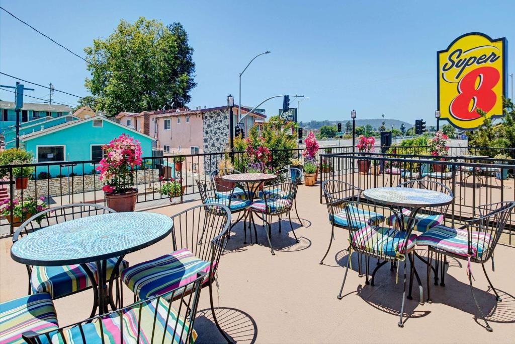 a patio with tables and chairs and a sign at Super 8 by Wyndham Santa Cruz/Beach Boardwalk East in Santa Cruz