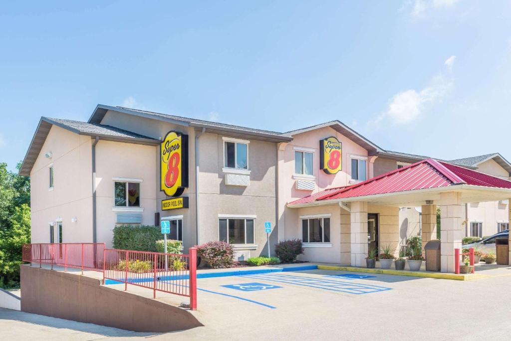 a building with a fast food restaurant in a parking lot at Super 8 by Wyndham Bloomington, Indiana in Bloomington