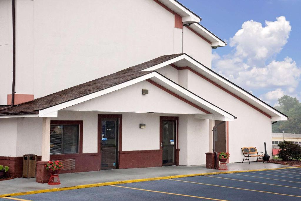 a large white building with a parking lot at Hillside Inn &amp; Suite in Martinsburg