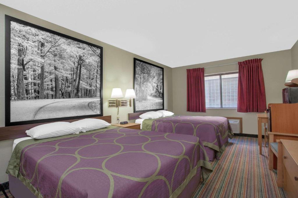 ein Hotelzimmer mit 2 Betten und einem TV in der Unterkunft Super 8 by Wyndham Evansville East in Evansville