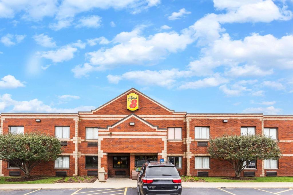 a brick building with a car parked in front of it at Super 8 by Wyndham Elgin in Elgin