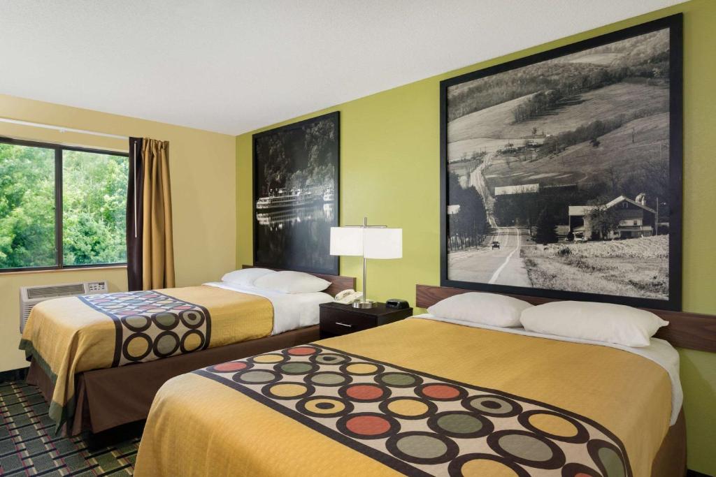 a hotel room with two beds and a picture on the wall at Super 8 by Wyndham Marietta in Marietta