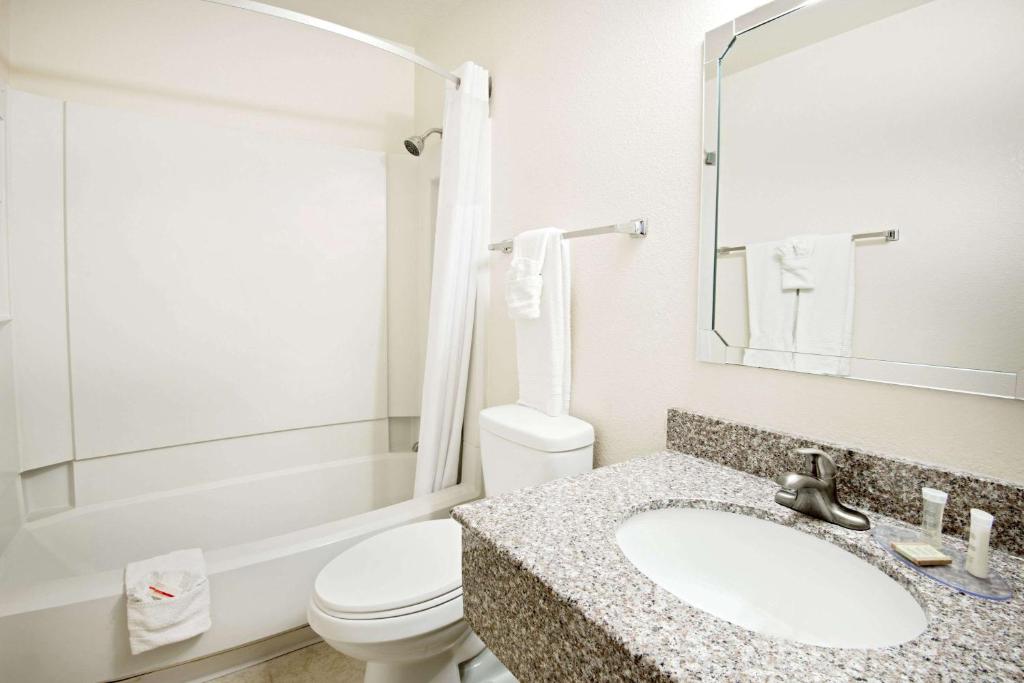 a bathroom with a sink and a toilet and a mirror at Super 8 by Wyndham Las Cruces/White Sands Area in Las Cruces