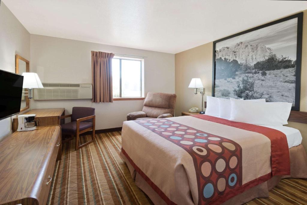 a hotel room with a large bed and a desk at Super 8 by Wyndham Las Cruces/White Sands Area in Las Cruces