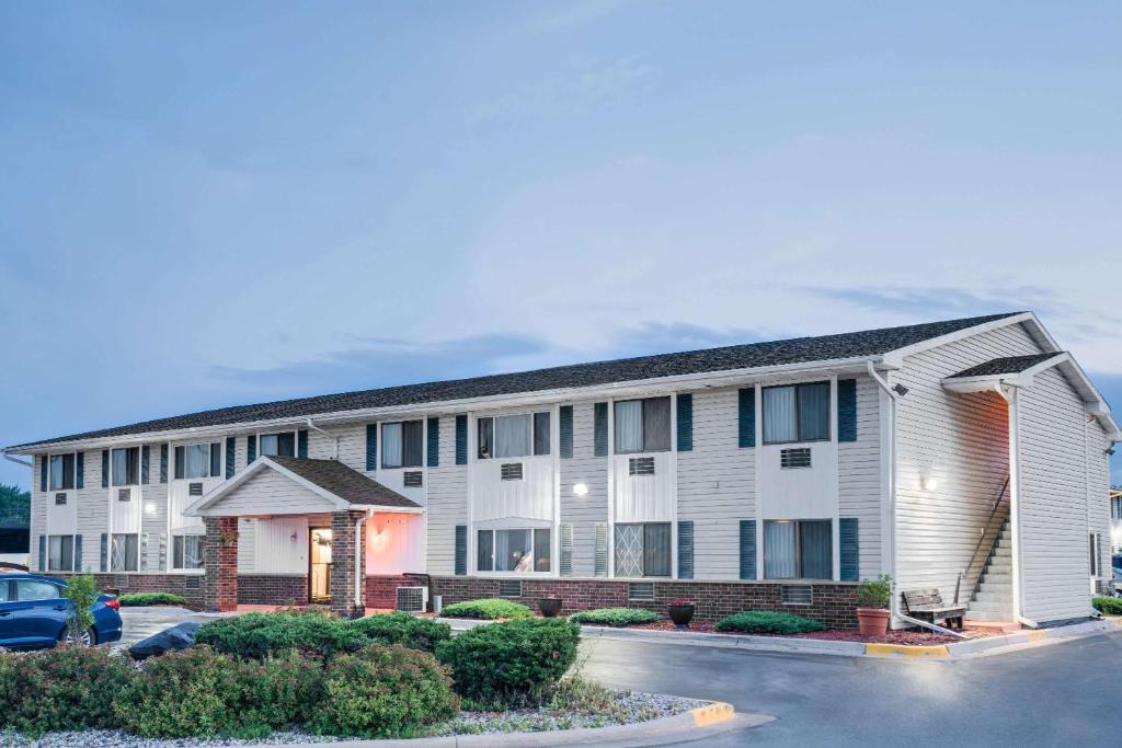 a building with a car parked in front of it at Super 8 by Wyndham Tomah Wisconsin in Tomah