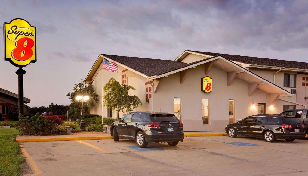 a store with two cars parked in a parking lot at Super 8 by Wyndham Keokuk in Keokuk