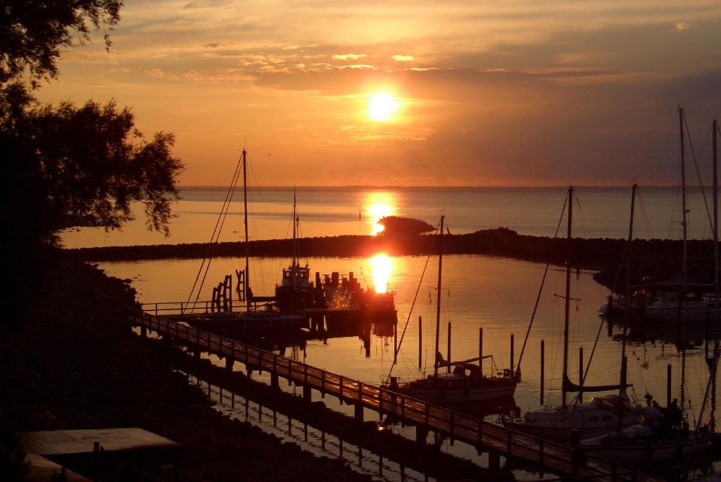 a sunset over a marina with boats in the water at Ferienwohnungen Arkonablick Schneidereit in Lohme