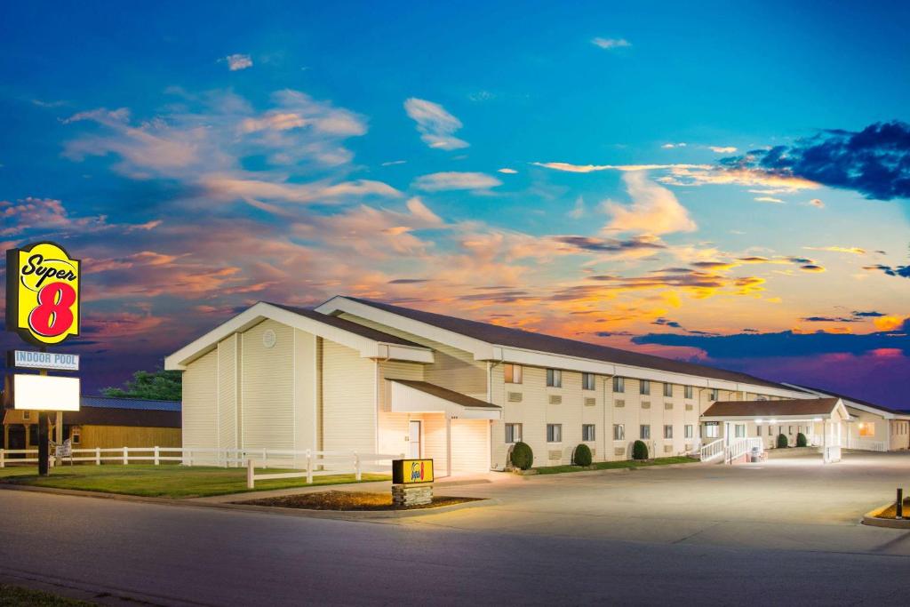 a large white building with a cloudy sky in the background at Super 8 by Wyndham Nevada in Nevada