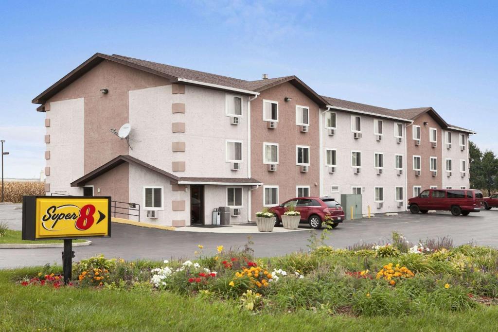 a large building with a sign in a parking lot at Super 8 by Wyndham Peru Starved Rock State Park in Peru