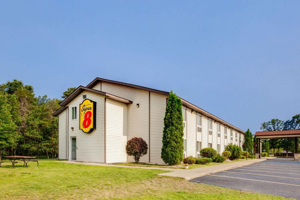 a building with a sign on the side of it at Super 8 by Wyndham Grayling in Grayling