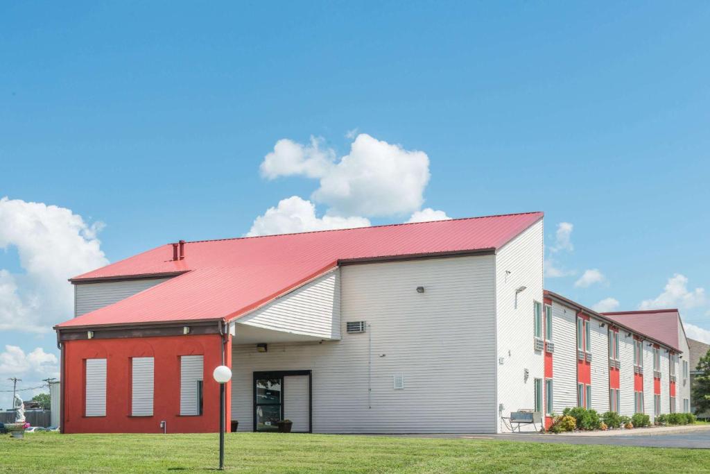 un gran edificio blanco y rojo con techo rojo en Super 8 by Wyndham O'Fallon MO/St. Louis Area, en O'Fallon