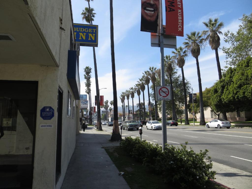 a city street with palm trees and a street sign at Budget Inn Hollywood in Los Angeles
