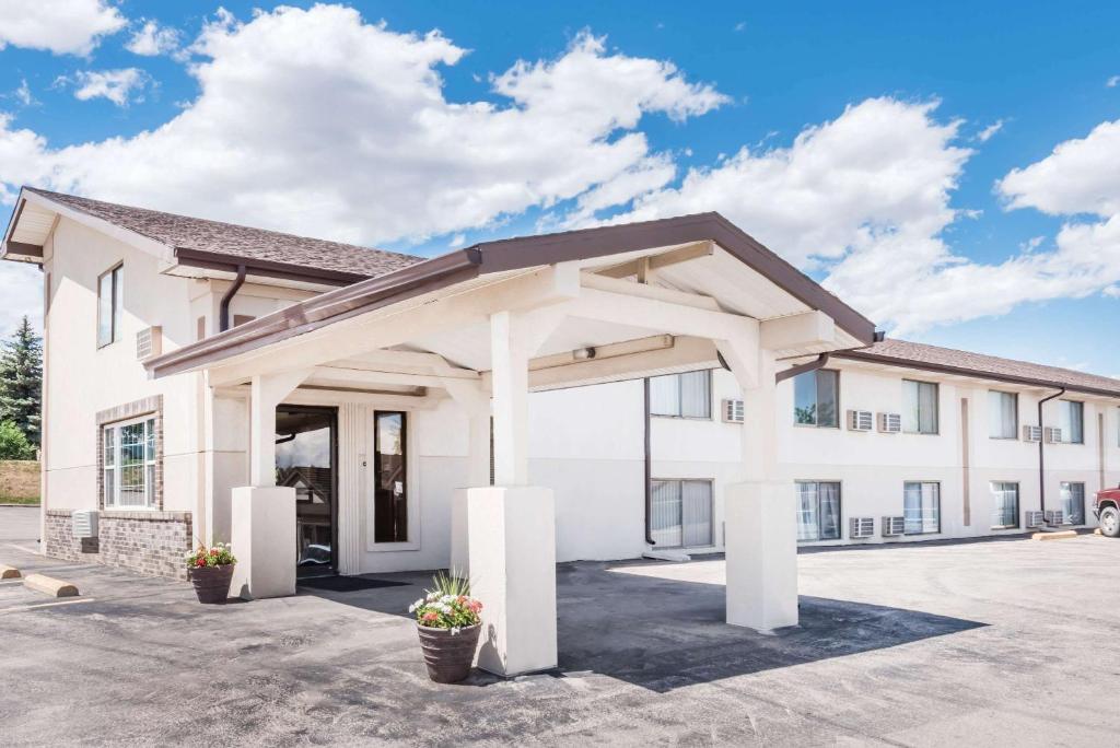 a large white building with a garage at Super 8 by Wyndham Belle Fourche SD in Belle Fourche
