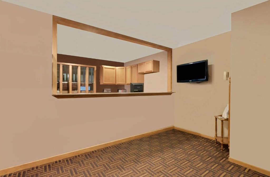 an empty room with a mirror and a tv at Super 8 by Wyndham Spearfish in Spearfish