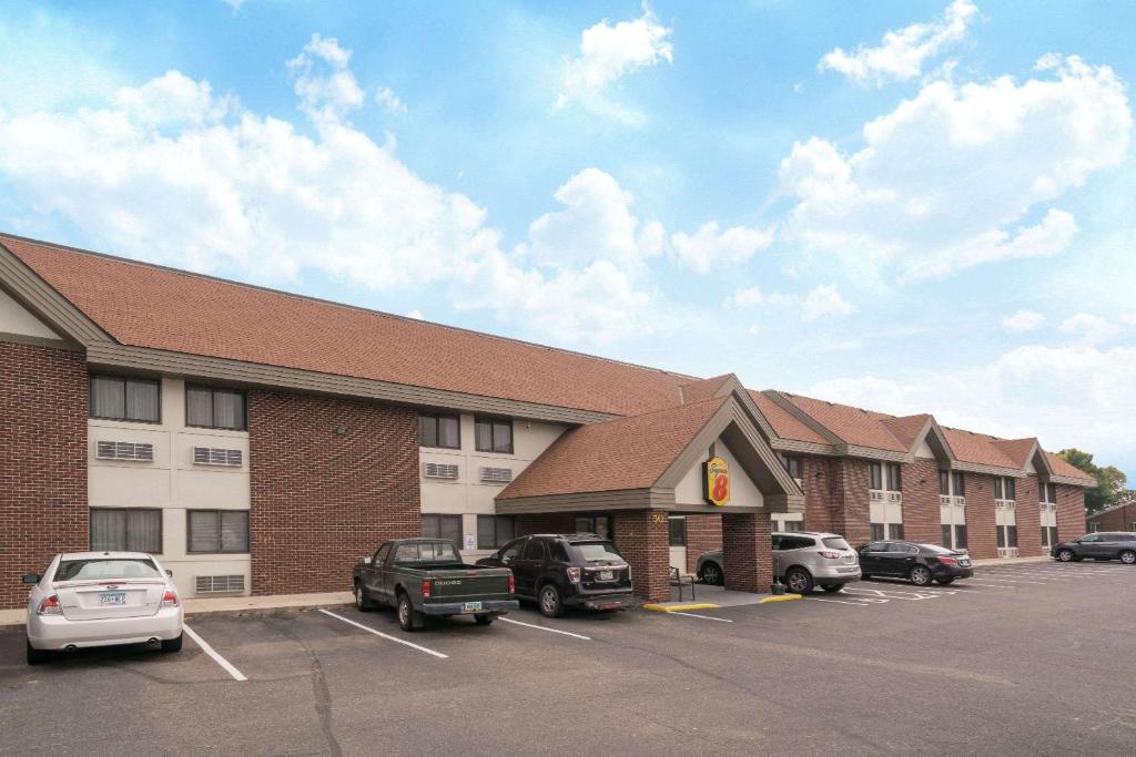 a large building with cars parked in a parking lot at Super 8 by Wyndham St. Cloud in Saint Cloud