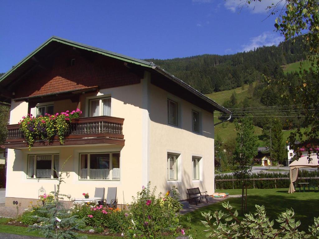 a white house with a balcony with flowers on it at Ferienhaus Försterlisl in Kleinarl