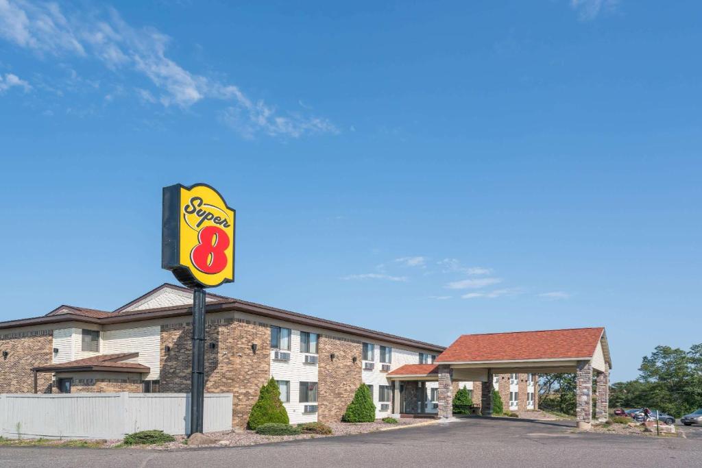 a hotel with a sign in front of a building at Super 8 by Wyndham Rice Lake in Rice Lake