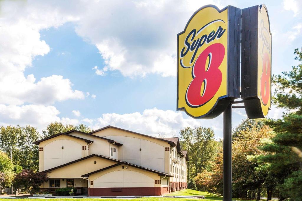 un cartello per un super otto motel di fronte a un edificio di Super 8 by Wyndham Stroudsburg a East Stroudsburg