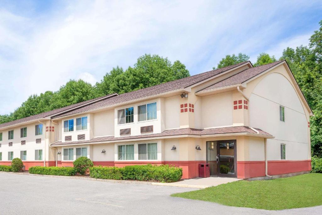 a large apartment building with a driveway at Super 8 by Wyndham Oneonta/Cooperstown in Oneonta