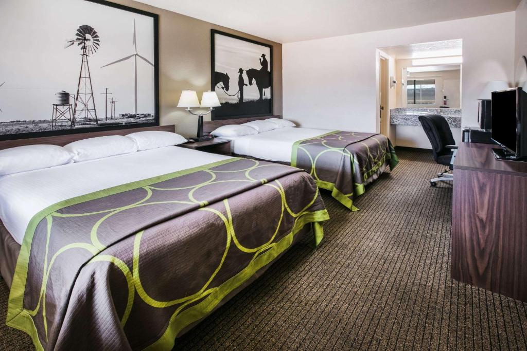 um quarto de hotel com duas camas e uma televisão de ecrã plano em Super 8 by Wyndham Oklahoma Airport Fairgrounds West em Oklahoma City