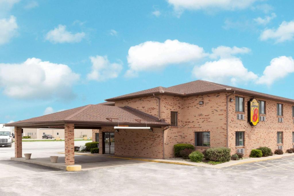 a front view of a hotel with a building at Super 8 by Wyndham Gilman in Gilman