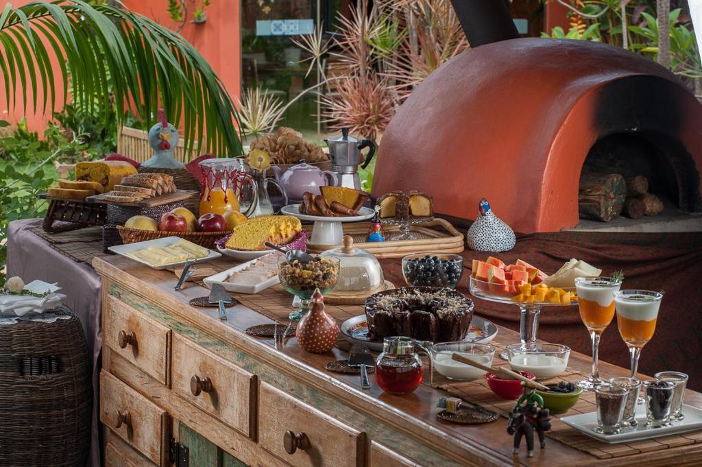 a buffet of food and drinks on a wooden table at Pousada Maya in Alto Paraíso de Goiás