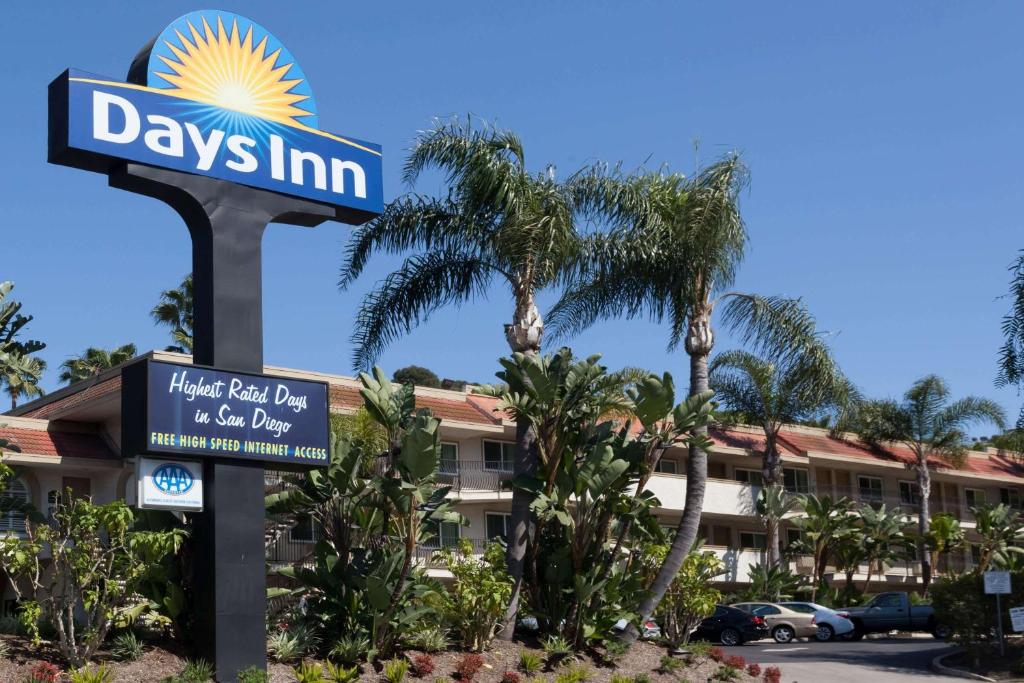 a sign in front of a hotel with palm trees at Days Inn by Wyndham San Diego Hotel Circle in San Diego