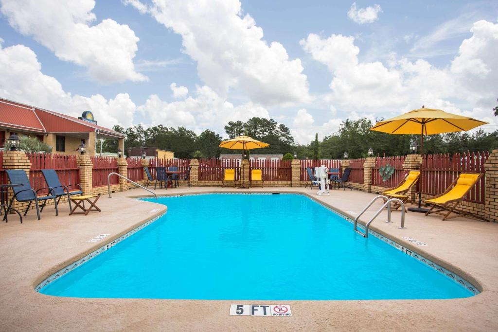 una piscina con sillas y sombrillas en un complejo en Days Inn by Wyndham Lake City, en Lake City