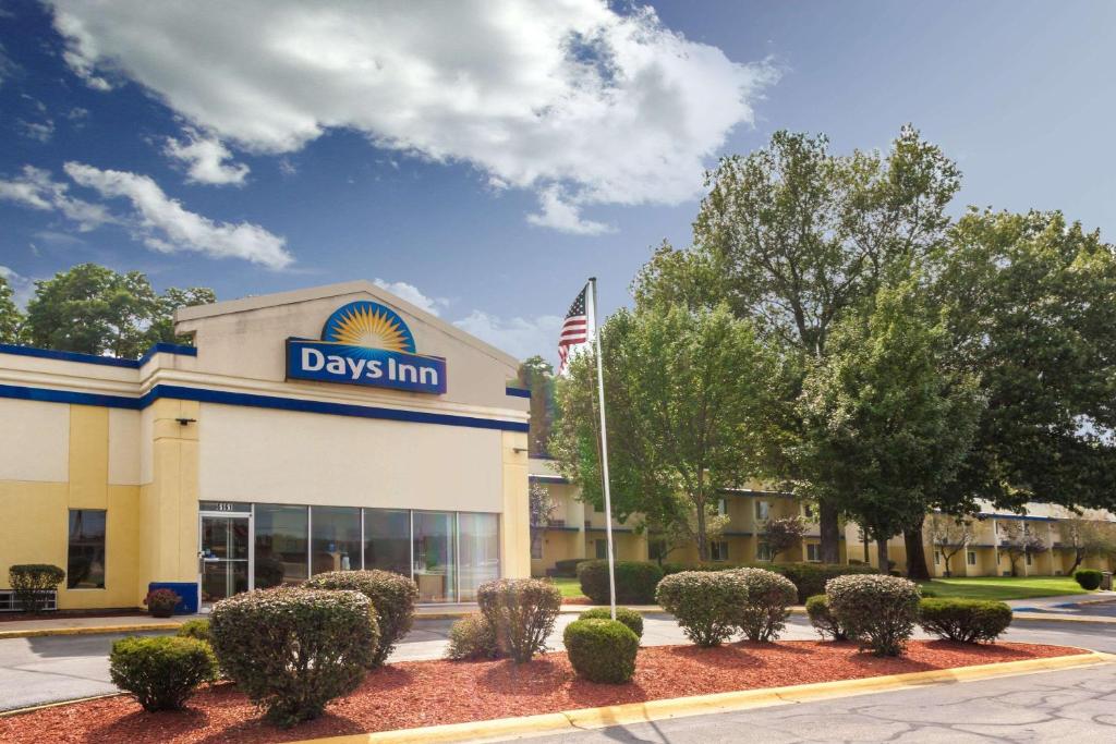 a view of a day inn building with a flag at Days Inn by Wyndham Portage in Portage