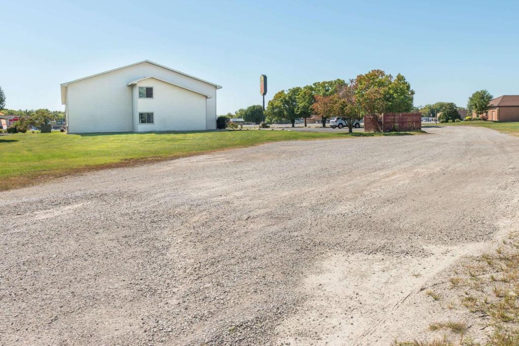 an empty dirt road with a building in the background at Super 8 by Wyndham Du Quoin in Du Quoin