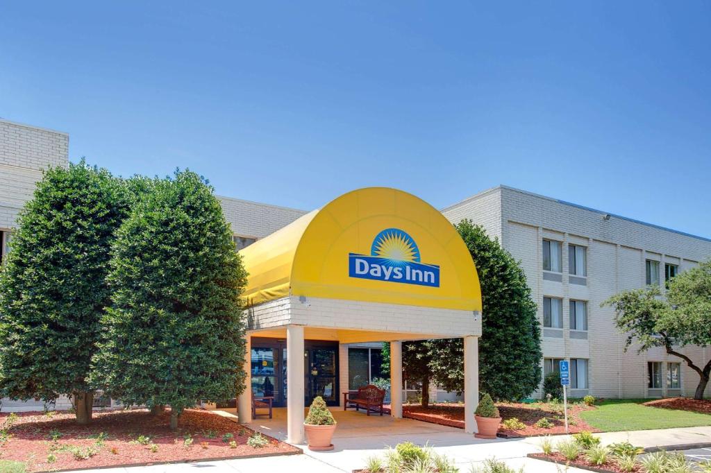 una señal de una posada frente a un edificio en Days Inn by Wyndham Newport News City Center Oyster Point, en Newport News