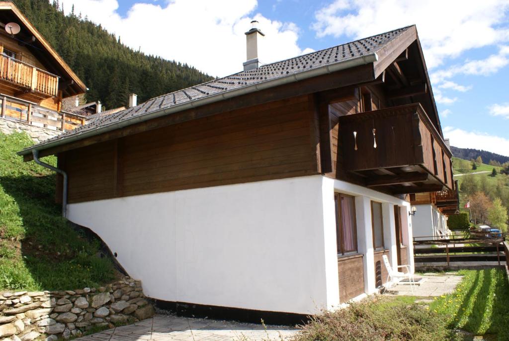 a white and brown building with a roof at Tschuggen 24 in Blatten bei Naters