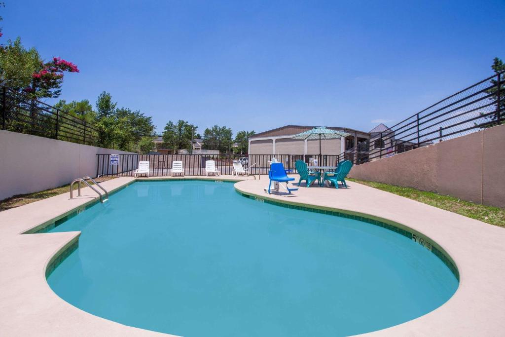 a swimming pool with two chairs and a swing at Super 8 by Wyndham Augusta in Augusta
