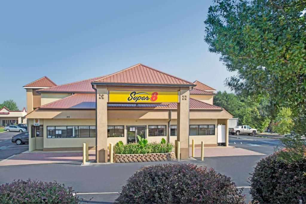 a store with a synergy sign in a parking lot at Super 8 by Wyndham Suwanee in Suwanee