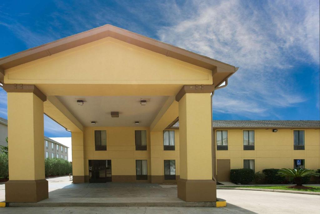 a large yellow building with awning in front of it at Super 8 by Wyndham Sulphur Lake Charles in Sulphur