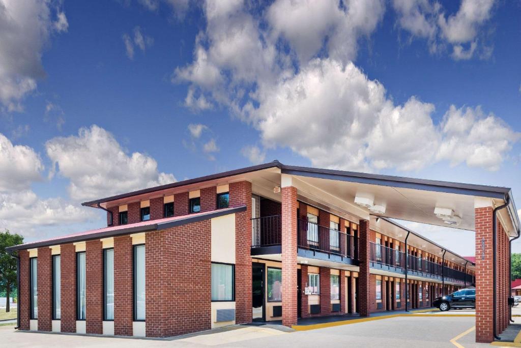 a large brick building with a car parked in front of it at Super 8 by Wyndham Chattanooga Ooltewah in Ooltewah