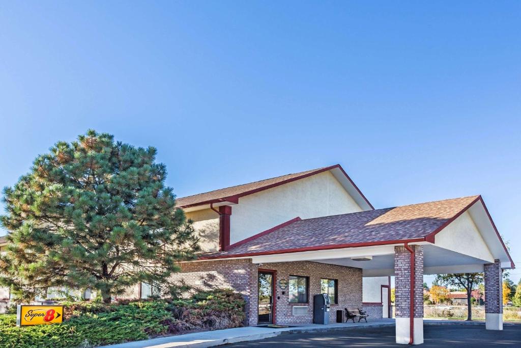 a building with a tree in front of it at Super 8 by Wyndham Greeley in Greeley