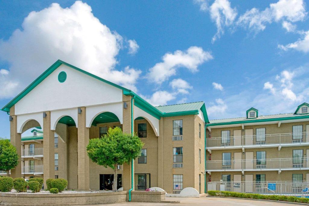 a large apartment building with a tree in front of it at Super 8 by Wyndham Lakeland in Lakeland