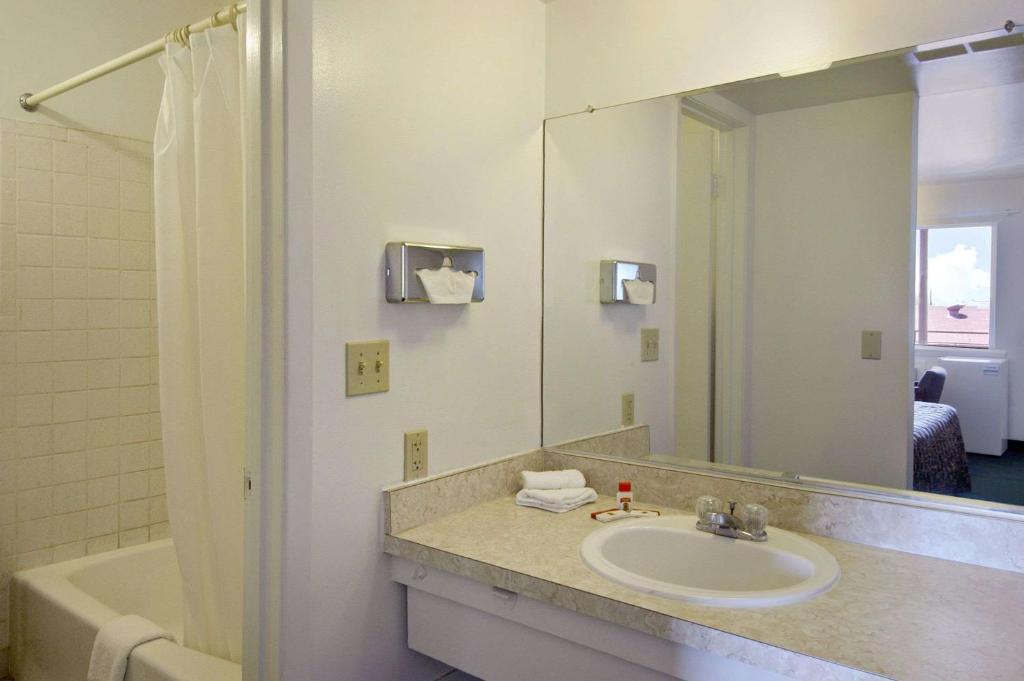 y baño con lavabo, espejo y bañera. en Super 8 by Wyndham Vernon, en Vernon
