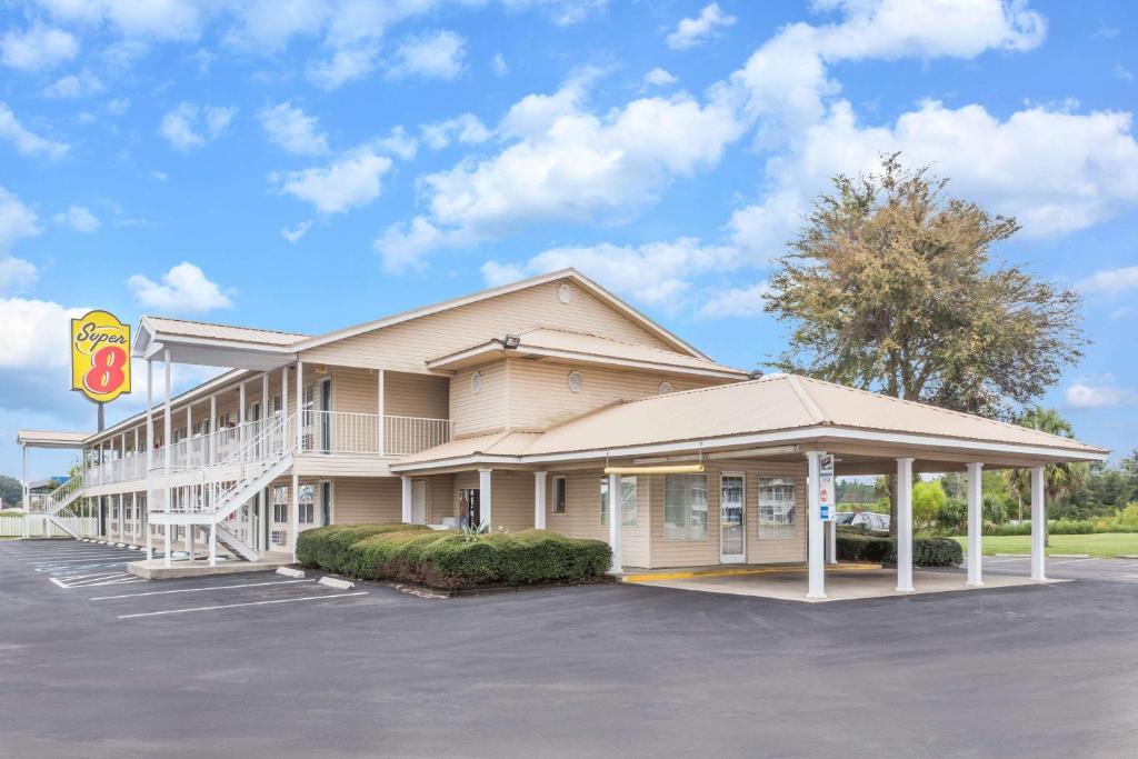 Un edificio con un estacionamiento enfrente. en Super 8 by Wyndham Madison, en Madison