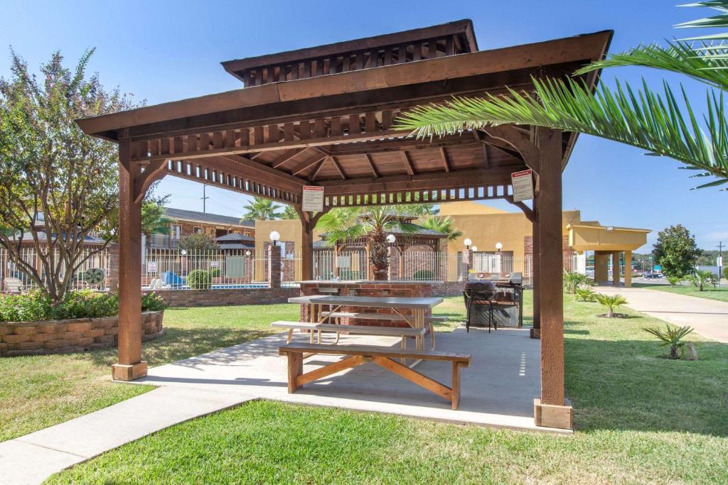 - un pavillon en bois avec une table de pique-nique dans un parc dans l'établissement Super 8 by Wyndham Tyler TX, à Tyler