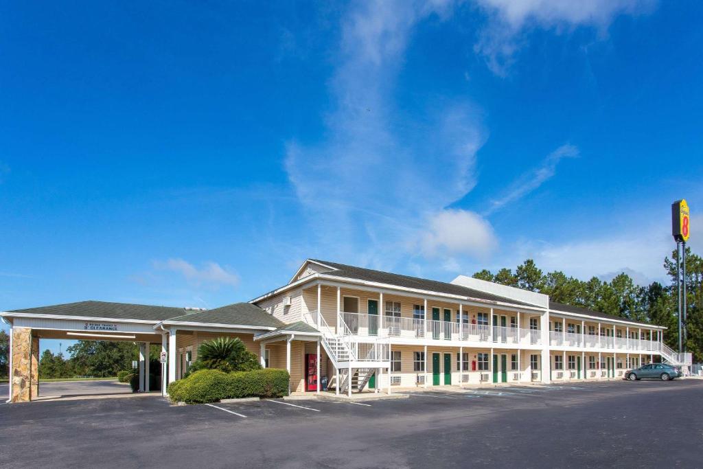 a building with a traffic light in front of it at Super 8 by Wyndham Monticello in Monticello