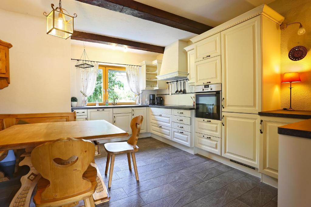 a kitchen with white cabinets and a wooden table at Landhaus Danita in Bodensdorf